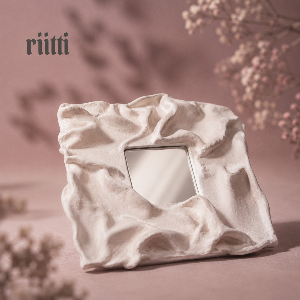 A hand-sculpted plaster mirror with a folded, draped frame
